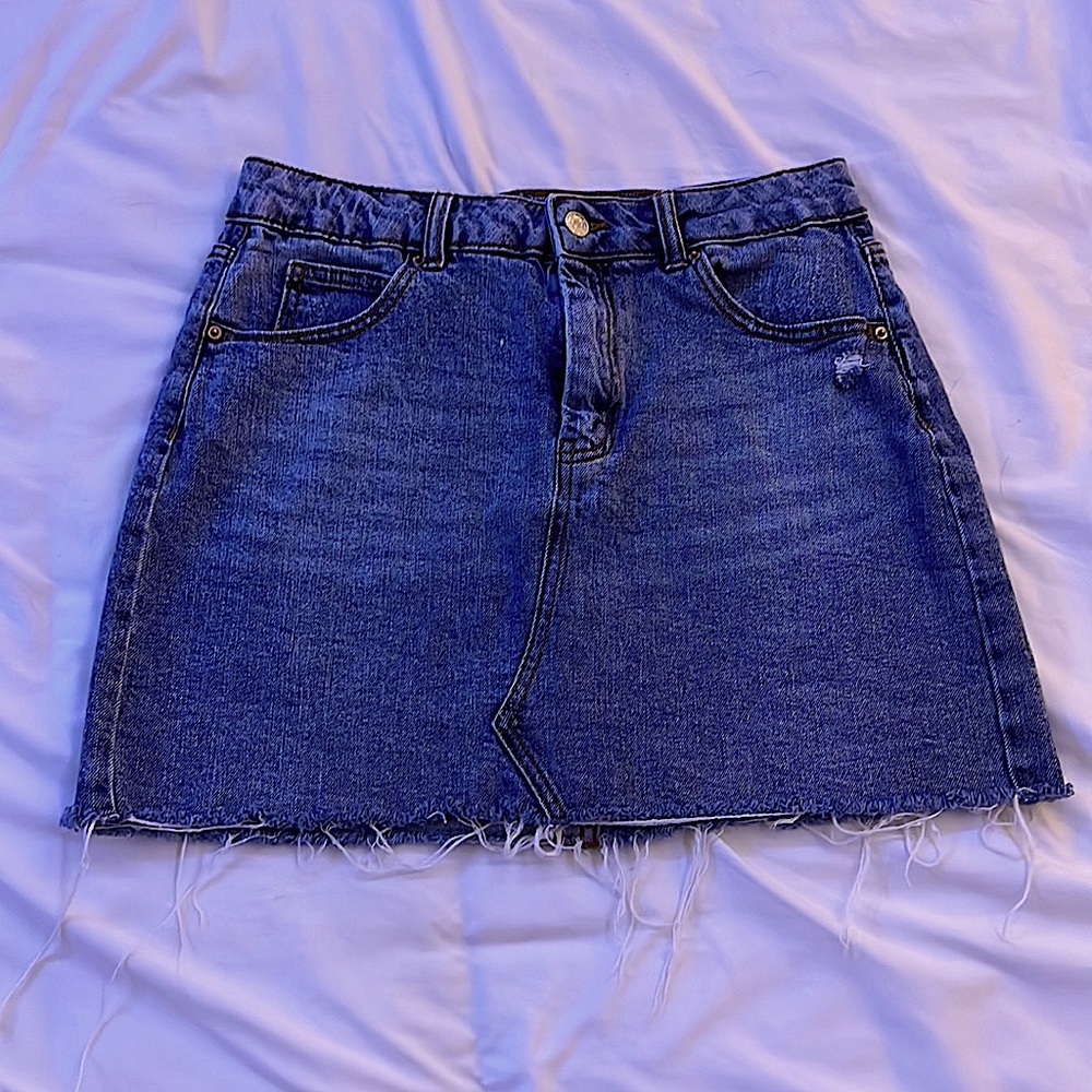 Blue jean skirt with decorative line down the middle.